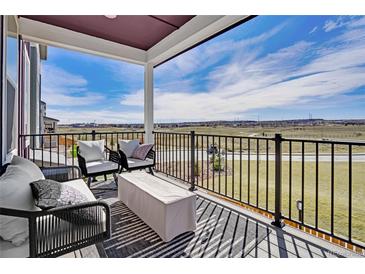 Inviting outdoor patio featuring stylish seating and scenic views of the surrounding landscape under a covered porch at 14998 Cast Pebble Cir, Parker, CO 80134