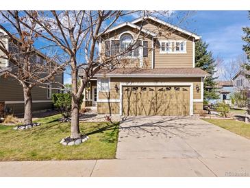 Charming two-story home featuring a two-car garage, mature landscaping, and a well-maintained lawn, creating great curb appeal at 5941 S Waco St, Aurora, CO 80016