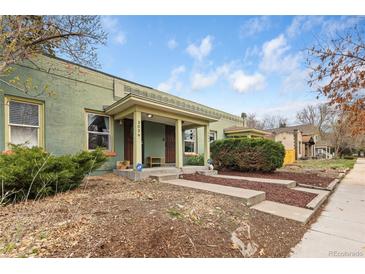 Charming home featuring a covered porch with tasteful landscaping and a well-maintained lawn at 3034 N High St, Denver, CO 80205