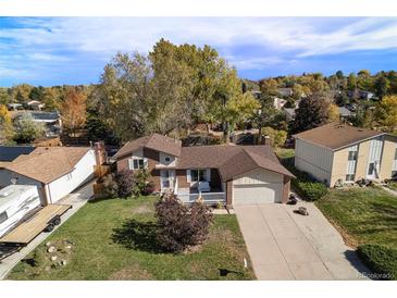 Aerial view of a charming single-Gathering home with well-maintained lawn, mature trees, and a cozy front porch at 3164 S Nucla St, Aurora, CO 80013