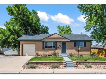 Charming single-story home with brick facade, attached garage, and manicured front yard at 2069 E 116Th Ave, Northglenn, CO 80233