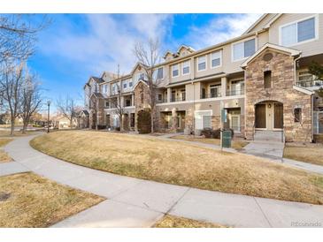 Tan townhouse building with stone accents, set against a blue sky at 1535 S Florence Way # 407, Aurora, CO 80247