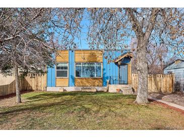 Charming home with a well-maintained front yard, mature trees, and blue painted exterior at 1937 Jay St, Lakewood, CO 80214