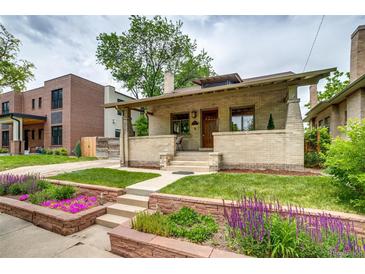 Charming brick home featuring a welcoming front porch and beautifully landscaped yard at 3525 N Alcott St, Denver, CO 80211
