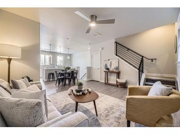 Bright living room with modern ceiling fan, neutral palette, wood floors, and open layout to kitchen at 3378 W 17Th Ave, Denver, CO 80204