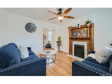 Inviting living room with hardwood floors, fireplace, and comfortable blue seating at 710 E Alameda Ave, Denver, CO 80209