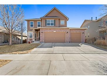 Beautiful two-story home featuring a brick facade and attached two car garage at 5128 Longs Peak St, Brighton, CO 80601