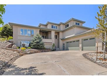 Spacious home featuring an attached three-car garage, elegant landscaping, and a welcoming front entrance at 6405 Eagle Feather Trl, Littleton, CO 80125