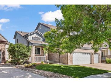 Charming two-story home with a well-maintained lawn and a three car garage at 11861 Fairplay St, Commerce City, CO 80603