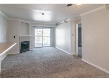 Bright living room with plush carpeting, fireplace, and access to the outdoor balcony at 12158 W Dorado Pl # 204, Littleton, CO 80127