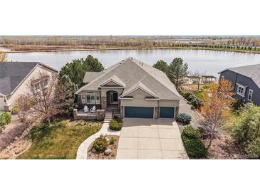 Well-manicured front lawn with large front porch and three car garage at 1738 Edgewater Pl, Longmont, CO 80504