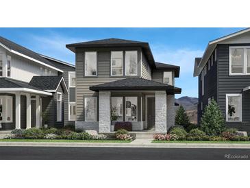 Charming two-story home showcasing a modern design with stone accents and manicured landscaping at 704 Belay St, Erie, CO 80516
