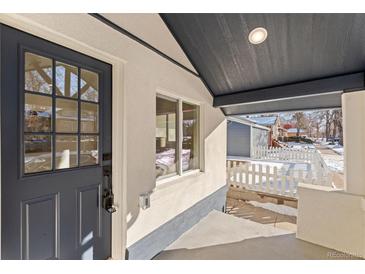 Inviting front porch with a gray door and white picket fence at 3756 Decatur St, Denver, CO 80211