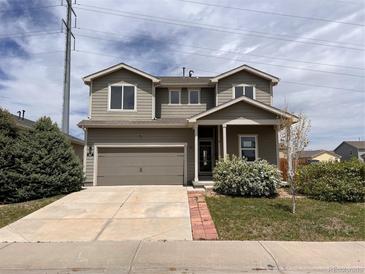 Two-story home with a well-maintained front yard, a two-car garage and neutral-colored siding at 317 Whimsical Ave, Brighton, CO 80603