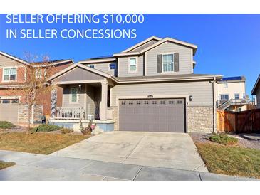 Charming two-story home featuring a two-car garage, a welcoming front porch, and manicured front lawn at 9448 Richfield St, Commerce City, CO 80022
