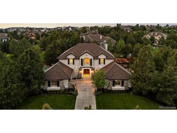 Beautiful home showcasing a manicured lawn, lush landscaping, and inviting front entrance at 6122 Maroon Peak Pl, Castle Rock, CO 80108