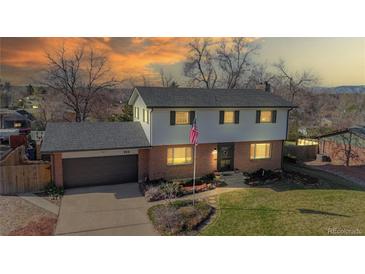 Charming two-story home with brick accents, a well-kept lawn and an American flag at 954 E Costilla Ave, Centennial, CO 80122