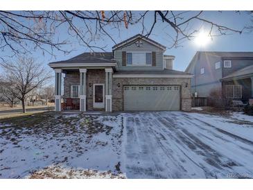 Two-story brick home with attached garage and landscaping at 19556 E 58Th Pl, Aurora, CO 80019