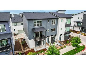 Modern townhome featuring a gray and white exterior, balcony, and well-maintained landscaping at 2052 Alcott Way, Broomfield, CO 80023