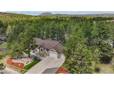 Stunning aerial view of home, showcasing lush surroundings and mountain backdrop at 1151 Kenosha Dr, Larkspur, CO 80118