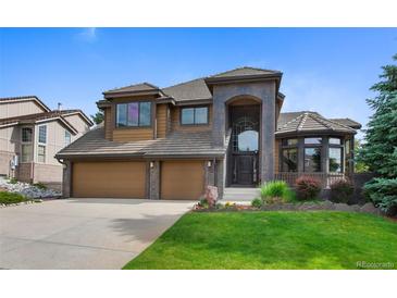 Inviting home featuring a grand entrance, three-car garage, and well-manicured lawn at 34 Amaranth Dr, Littleton, CO 80127