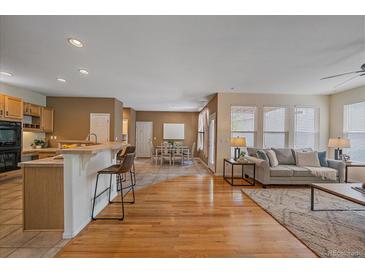 Inviting living room flows into a well-lit dining area and kitchen with a breakfast bar at 11150 Night Heron Dr, Parker, CO 80134