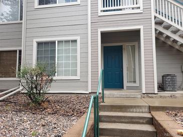 Charming condo featuring a vibrant blue front door and well-maintained exterior siding at 8425 Pebble Creek Way # 101, Highlands Ranch, CO 80126