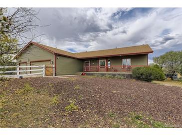 Charming home featuring an inviting porch and a well-manicured front yard at 11549 Haskell Creek Rd, Larkspur, CO 80118