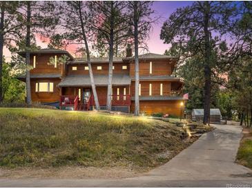 Inviting multi-story home with a red railed front porch, mature trees, and pathway leading to the residence at 8170 Lt William Clark Rd, Parker, CO 80134