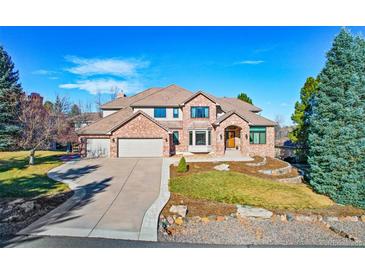 Beautiful brick home featuring a landscaped front yard, circular driveway, and multi-car garage at 9 Mule Deer Trl, Littleton, CO 80127