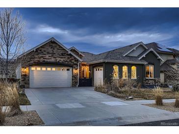 Beautiful home exterior showcases a two-car garage, manicured lawn, and inviting curb appeal at dusk at 9521 Garnett Way, Arvada, CO 80007