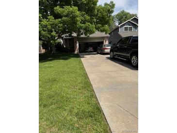Cozy single-Gathering home with mature trees, a well-manicured lawn, and driveway at 5201 E 127Th Dr, Thornton, CO 80241