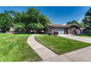 Charming brick home featuring a well-manicured lawn, mature trees, and a welcoming walkway to the front door at 5380 S Prescott St, Littleton, CO 80120