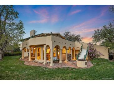 Inviting back patio with stone flooring, pillars, fire pit, and staircase to the second level at dusk at 1069 Crestmoor Dr, Boulder, CO 80303