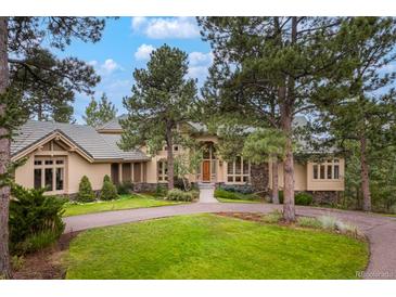 Beautiful home exterior with circular driveway, mature trees, and a well-manicured lawn at 2521 Juniper Ct, Golden, CO 80401