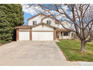 Charming two-story home with a three-car garage, well-maintained lawn, and mature trees at 5596 S Urban St, Littleton, CO 80127