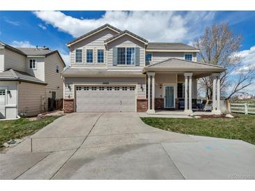Charming two-story home with a well-manicured lawn, inviting front porch, and attached two-car garage at 19593 E Hollow Creek Dr, Parker, CO 80134