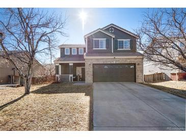 Charming two-story home with a well-manicured lawn and attached two car garage at 19430 E 58Th Dr, Aurora, CO 80019