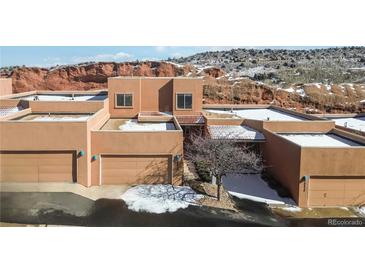 Modern stucco home with flat roof and attached garage located in the red rock formations of Colorado Springs at 10576 Roxborough Dr, Littleton, CO 80125