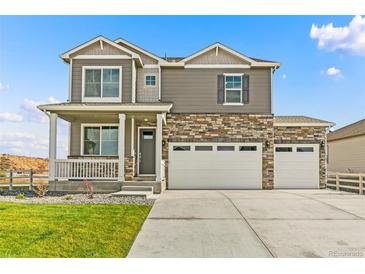 Two-story house with a two-car garage, landscaping, and a large driveway at 7548 E 159Th Pl, Thornton, CO 80602