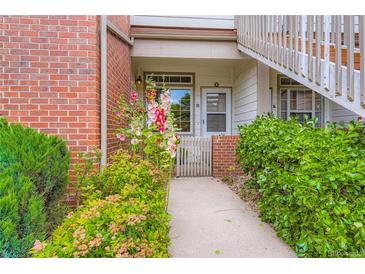 Charming condo entrance with beautiful flower beds and brick accents creating a welcoming appeal at 3040 W Prentice Ave # B, Littleton, CO 80123
