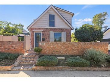 Charming brick home featuring a brick facade, landscaped front yard, and traditional architectural details at 824 E Iowa Ave, Denver, CO 80210