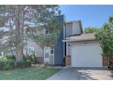 Two-story home with gray siding, brick accents, attached garage, and mature landscaping at 562 W Crestline Cir # 7D, Littleton, CO 80120