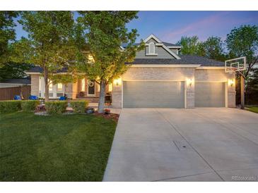 Charming brick home boasts a spacious three-car garage and beautifully landscaped front yard at 10188 Stephen Pl, Highlands Ranch, CO 80130