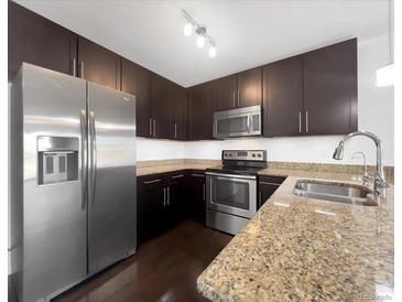 Modern kitchen features stainless steel appliances, granite countertops, and dark wood cabinetry at 1062 Rockhurst Dr # 302, Highlands Ranch, CO 80129