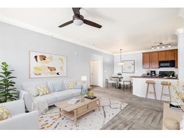 Bright living room boasts modern decor, open layout, and a smooth transition into the dining and kitchen area at 2662 S Cathay Way # 302, Aurora, CO 80013