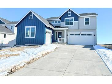 Two-story home with blue and gray siding, attached garage, and landscaping at 39440 Congress Ln, Elizabeth, CO 80107