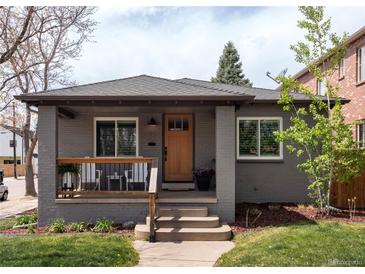 Charming gray brick home with a cozy front porch and manicured lawn at 489 S Gaylord St, Denver, CO 80209