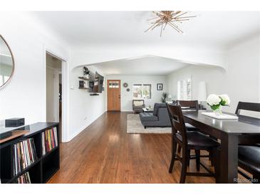 Open-concept living and dining area with hardwood floors and abundant natural light at 489 S Gaylord St, Denver, CO 80209