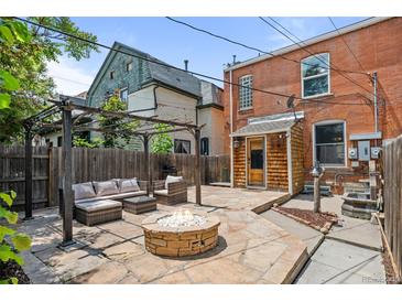 Cozy backyard featuring a stone patio, fire pit, and outdoor seating area with a pergola, perfect for entertaining at 14 S Lincoln St # 16, Denver, CO 80209